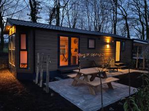 a small cabin with a picnic table and a bench at Gezellig vakantiechalet in bosrijke omgeving op de Veluwe in Epe