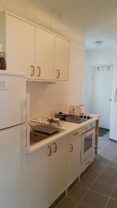 a kitchen with white cabinets and a sink at Skólavörðustígur Apartments in Reykjavík +29 photos