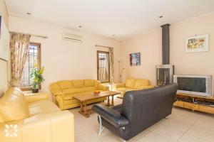 a living room with yellow furniture and a television at Villa Medina 20 by Abahana Villas in Moraira