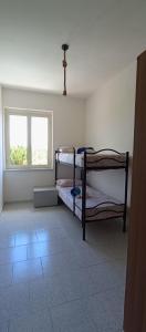 une chambre avec deux lits superposés et une fenêtre dans l'établissement Casa torelli azzurro, à Sellia Marina