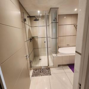 a bathroom with a shower and a tub and a sink at SUPER MARES_Comfortable & Cozy Apartment in Maputo +33 photos
