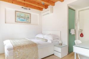 a white bedroom with a bed and a desk at Villa Valeria in Split