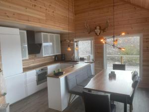 a kitchen with a table and a dining room at Ferienhaus Trollebo in Sinnes