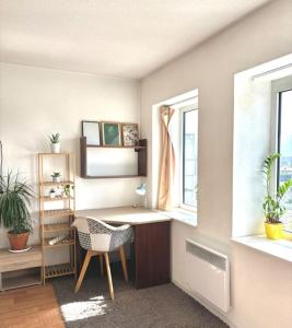 Zimmer mit einem Schreibtisch, einem Stuhl und 2 Fenstern in der Unterkunft Superbe Appartement Lumineux in Rennes