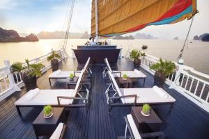 a boat with tables and chairs on the deck at Hera Cruises Group on Ha Long Bay in Ha Long