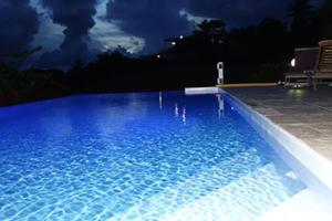 ein großer blauer Pool in der Nacht in der Unterkunft Appartement de charme dans villa avec piscine in Saint-François + 6 Fotos