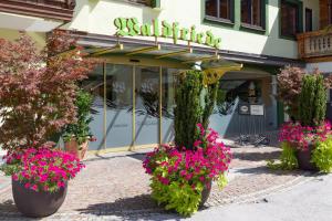 een winkel met bloempotten ervoor bij Hotel Waldfriede - Der Logenplatz im Zillertal in Fügen