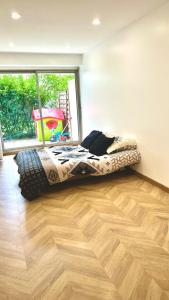1 dormitorio con cama en el suelo de madera y ventana en Appartement centre de Paris avec Parking et terrasses, en París