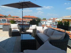 a patio with couches and an umbrella on a roof at Residhome Arcachon Plazza in Arcachon