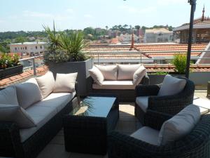 a patio with couches and chairs on a roof at Residhome Arcachon Plazza in Arcachon