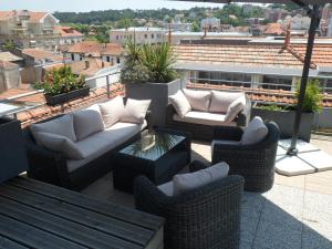 a patio with couches and tables on a roof at Residhome Arcachon Plazza in Arcachon