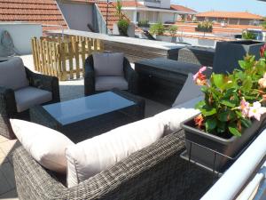 a patio with wicker chairs and a table and chairs at Residhome Arcachon Plazza in Arcachon