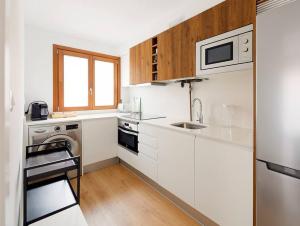 a white kitchen with a sink and a dishwasher at Magnifico apartamento en Llanes in Llanes
