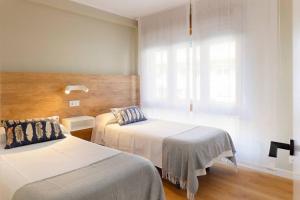 a hotel room with two beds and a window at Magnifico apartamento en Llanes in Llanes