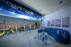 Apartamenty w Sky Tower في فروتسواف: غرفة معيشة مع أريكة زرقاء وطاولة