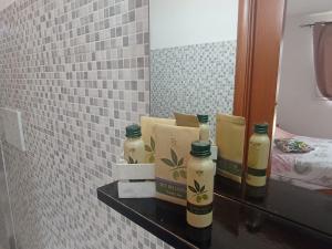 three bottles of soap on a shelf in a bathroom at Stanze Agli Ulivi in Porto Cesareo