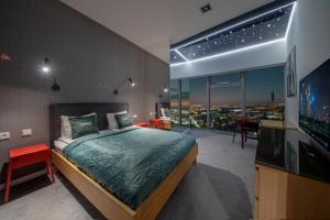 een slaapkamer met een bed en een flatscreen-tv bij Apartamenty w Sky Tower in Wrocław