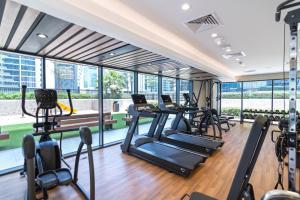 un gimnasio con cintas de correr y máquinas elípticas en CitiHome - Newly Furnished Apartment in Business Bay, en Dubái