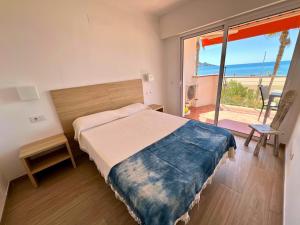 een slaapkamer met een bed en uitzicht op de oceaan bij EUROPA 13 in Roses