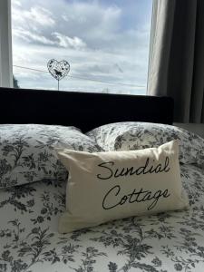 a bed with a pillow with the words annual coffee at Sundial Cottage in Newton Abbot