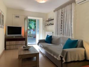 a living room with a couch and a tv at Yalos Studio in Stavros