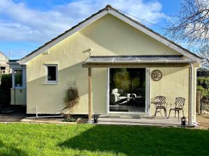 a house with a porch with a table and chairs at Sundial Cottage in Newton Abbot
