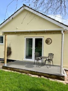 a patio with two chairs and a table on a house at Sundial Cottage in Newton Abbot +10 photos