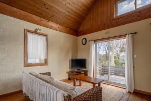 a living room with a couch and a table and a tv at Oceanic House TAMATEBAKO in Ito