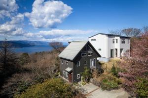 una vista aérea de una casa en una colina con un lago en Oceanic House TAMATEBAKO, en Ito