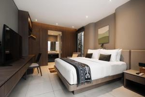 a hotel room with a large bed and a television at Mahitala Villa Bandung Heated Pool in Bandung