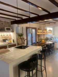 a kitchen with a large island with black bar stools at rural-home callemayor in Altura