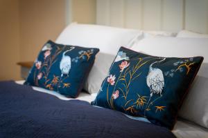 two pillows on a bed with blue sheets and flowers at Onda Marina Suites in Cagliari +14 photos
