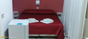 a red room with a bed with towels on it at Bed and Breakfast Almaran in Trapani