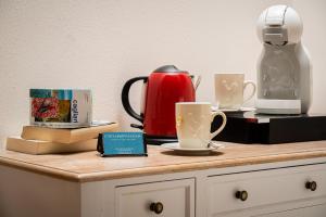 a counter with coffee cups and a tea kettle at Onda Marina Suites in Cagliari
