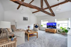 a living room with a couch and a tv at Finest Retreats - Courtyard Cottage in Kendal