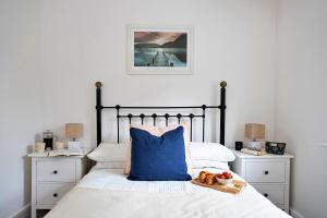 a bedroom with a bed with a blue pillow and two night stands at Finest Retreats - Courtyard Cottage in Kendal