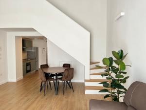 a dining room with a table and chairs and stairs at Santo Stefano Loft in Bologna