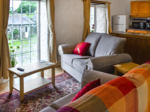 Hay Barn - Uk46197 في Budock Water: غرفة معيشة مع أريكة وطاولة