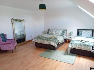 una camera con due letti, uno specchio e una sedia di Charlestown bungalow a Dundalk