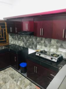 a kitchen with red cabinets and a stove in it at Ananyah Villa in Trincomalee