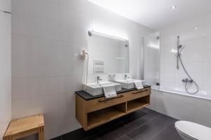 a white bathroom with two sinks and a shower at Bellevue Residences - Luxurious Lakeside Apartments in Zell am See +143 photos