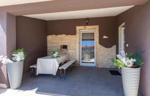 a table and chairs on a patio with plants in vases at Stunning Home In Hrboki With Wifi in Hrboki