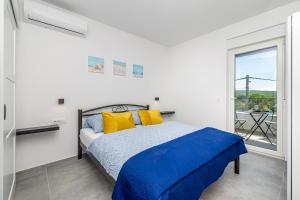 a bedroom with a bed with yellow and blue pillows at Vila KATHARINA s privatnim bazenom in Žgaljić +33 photos