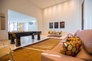 a living room with a pool table and a couch at Casa c/ Piscina de borda infinita e vista p/ Lago in Caldas Novas