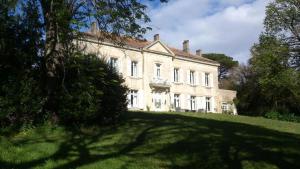 una gran casa blanca en un campo de hierba en Chateau de Thuries en Revel