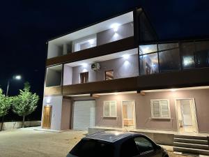 a car parked in front of a building at night at Alessio Rooms Kruja in Krujë