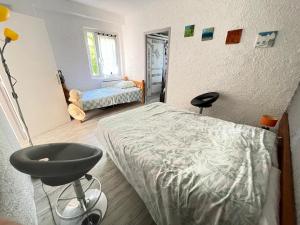 a bedroom with a bed and a chair in it at Apt 4-6pers-piscine-parc arboré in Fitou +23 photos