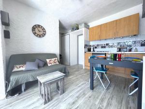 a small living room with a couch and a table at Apt 4-6pers-piscine-parc arboré in Fitou