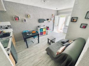 a living room with a couch and a table at Apt 4-6pers-piscine-parc arboré in Fitou