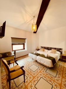 a bedroom with a bed and a desk and a chair at Hotel 3* La Casona de las Flores in Ondara